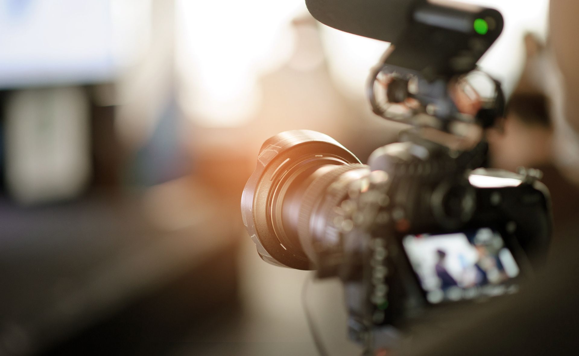 Close-up of a DSLR camera with a blurred background and bright lens flare