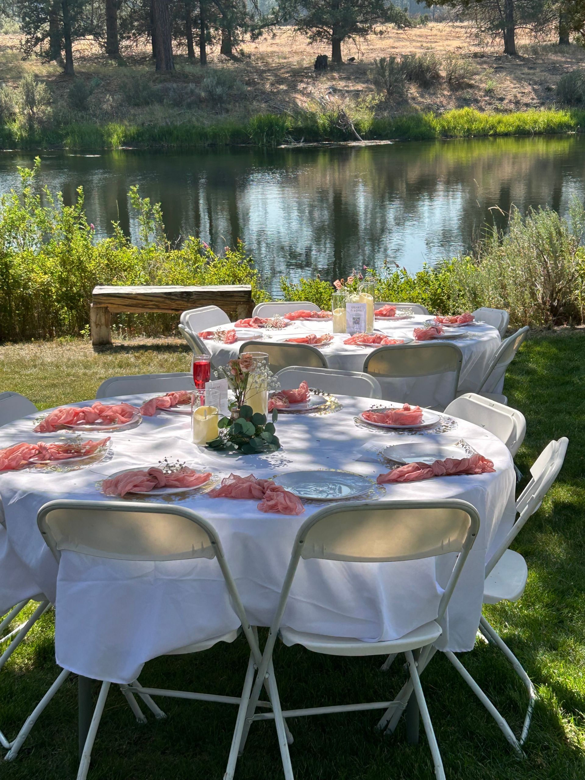 A table and chairs are set up in front of a lake.