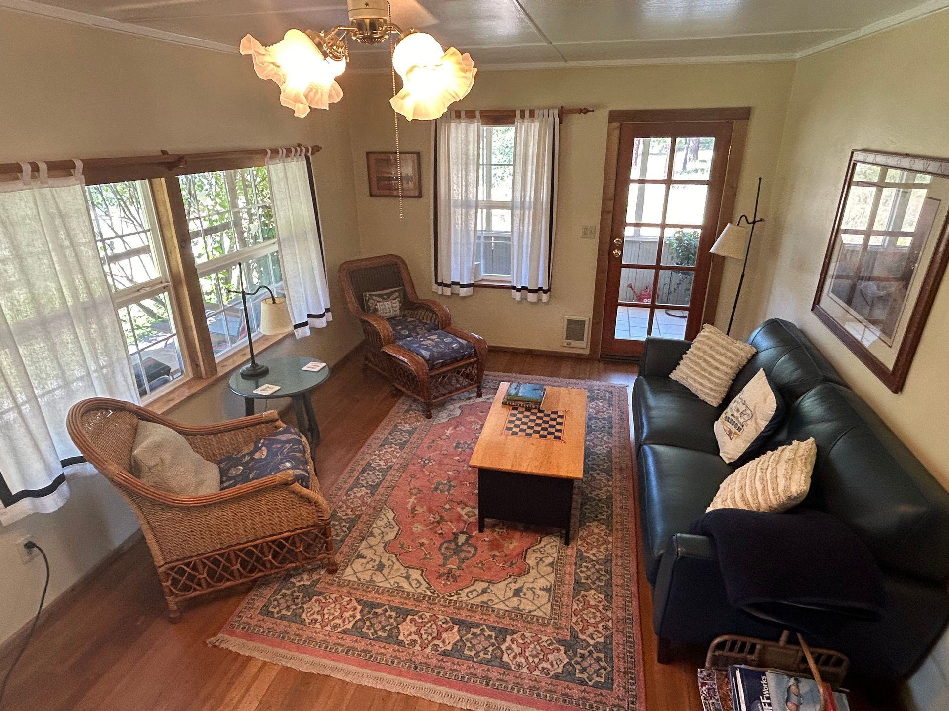 A living room with a couch , chairs , and a rug.