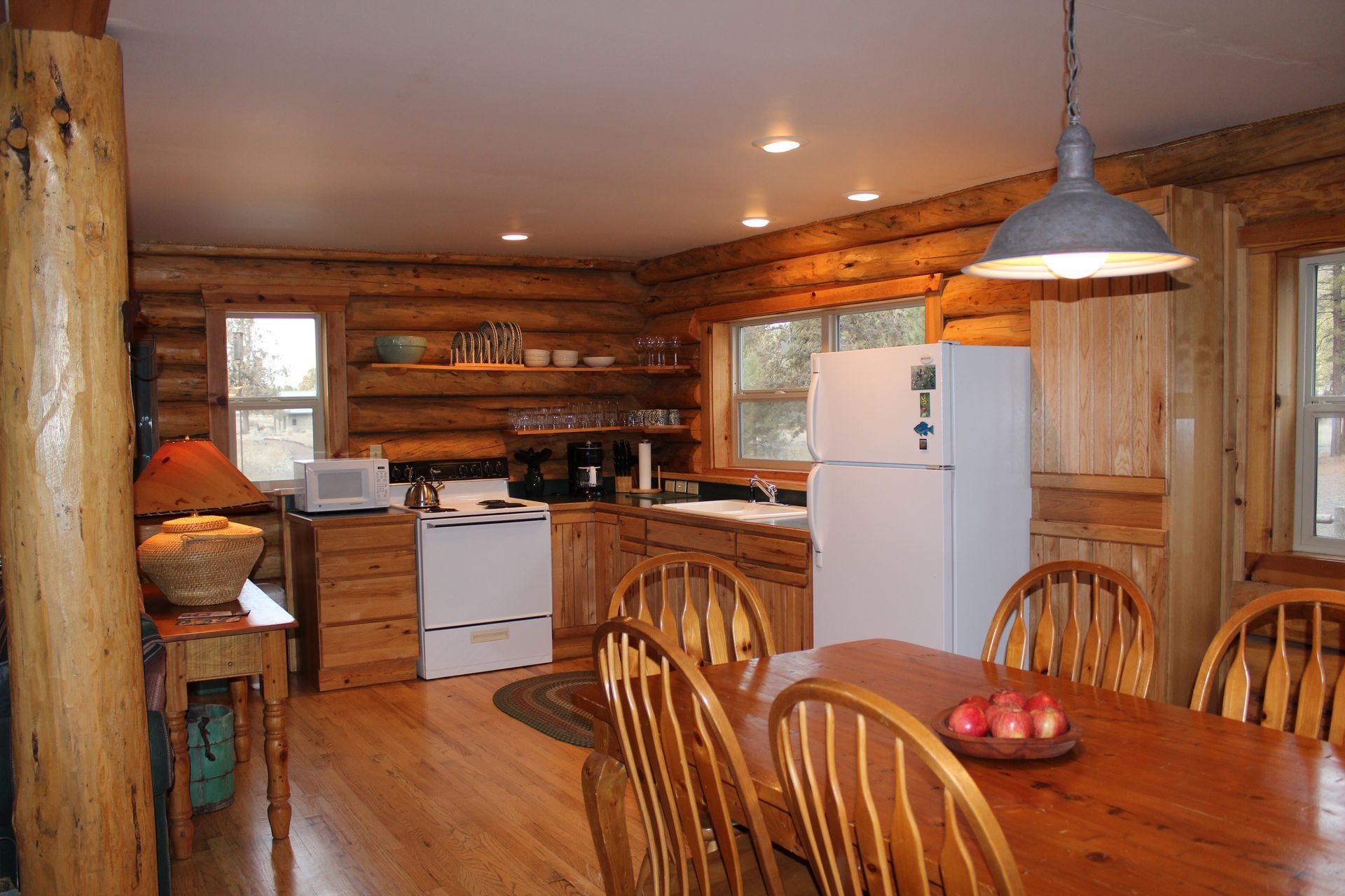 A kitchen in a log cabin with a table and chairs