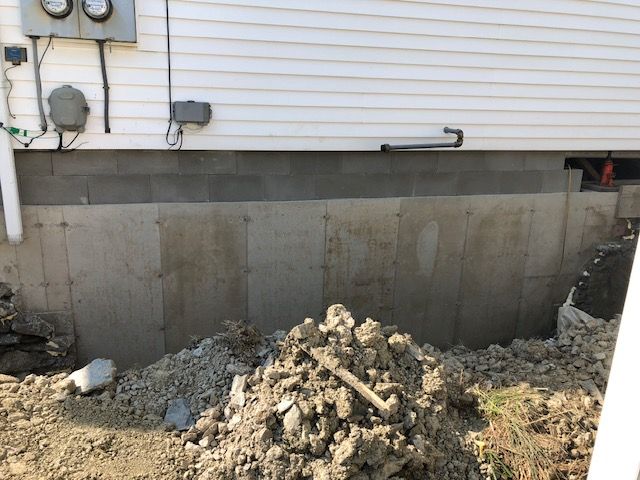 A pile of dirt is sitting in front of a house.
