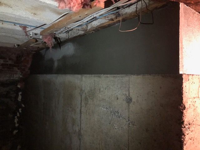 A concrete wall is being built in a basement.