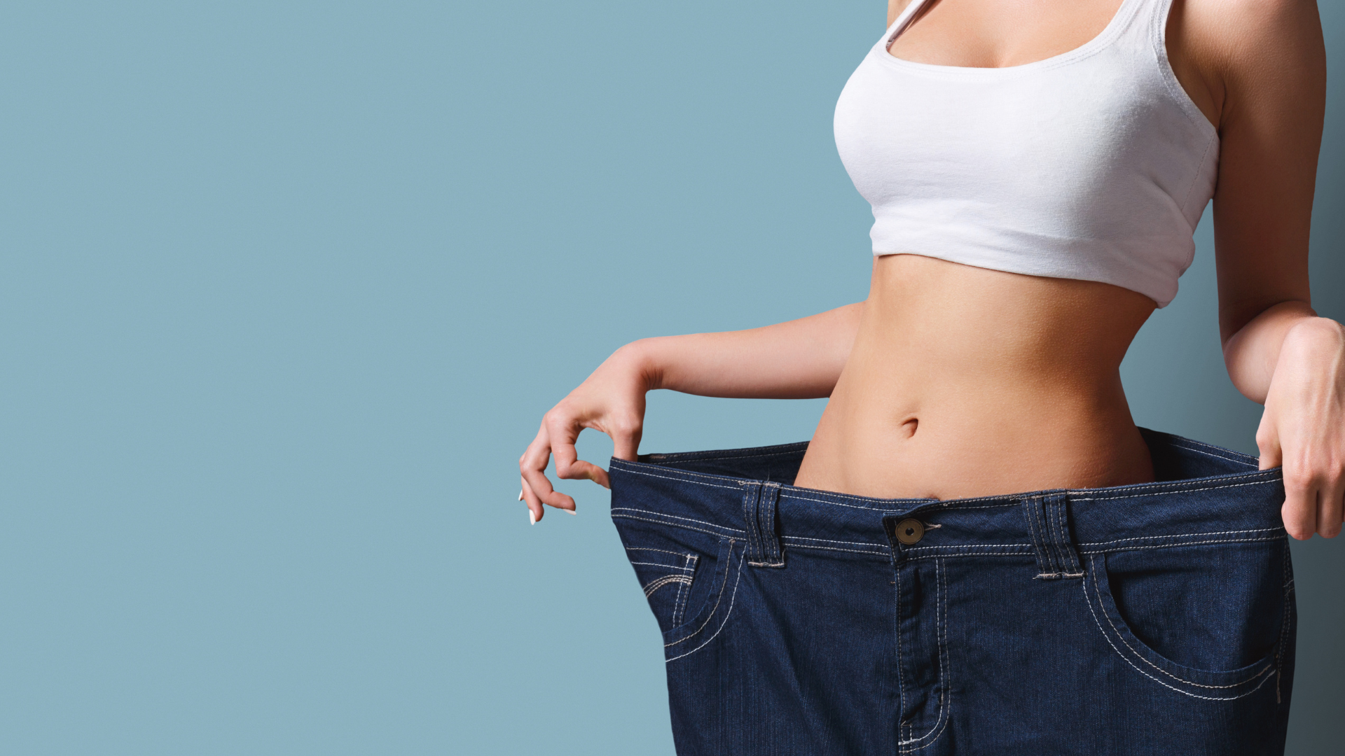A woman is wearing a pair of very large jeans.