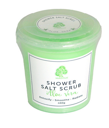 A light green container of Magina brand Aloe Vera shower salt scrub, 450g, against a white background.