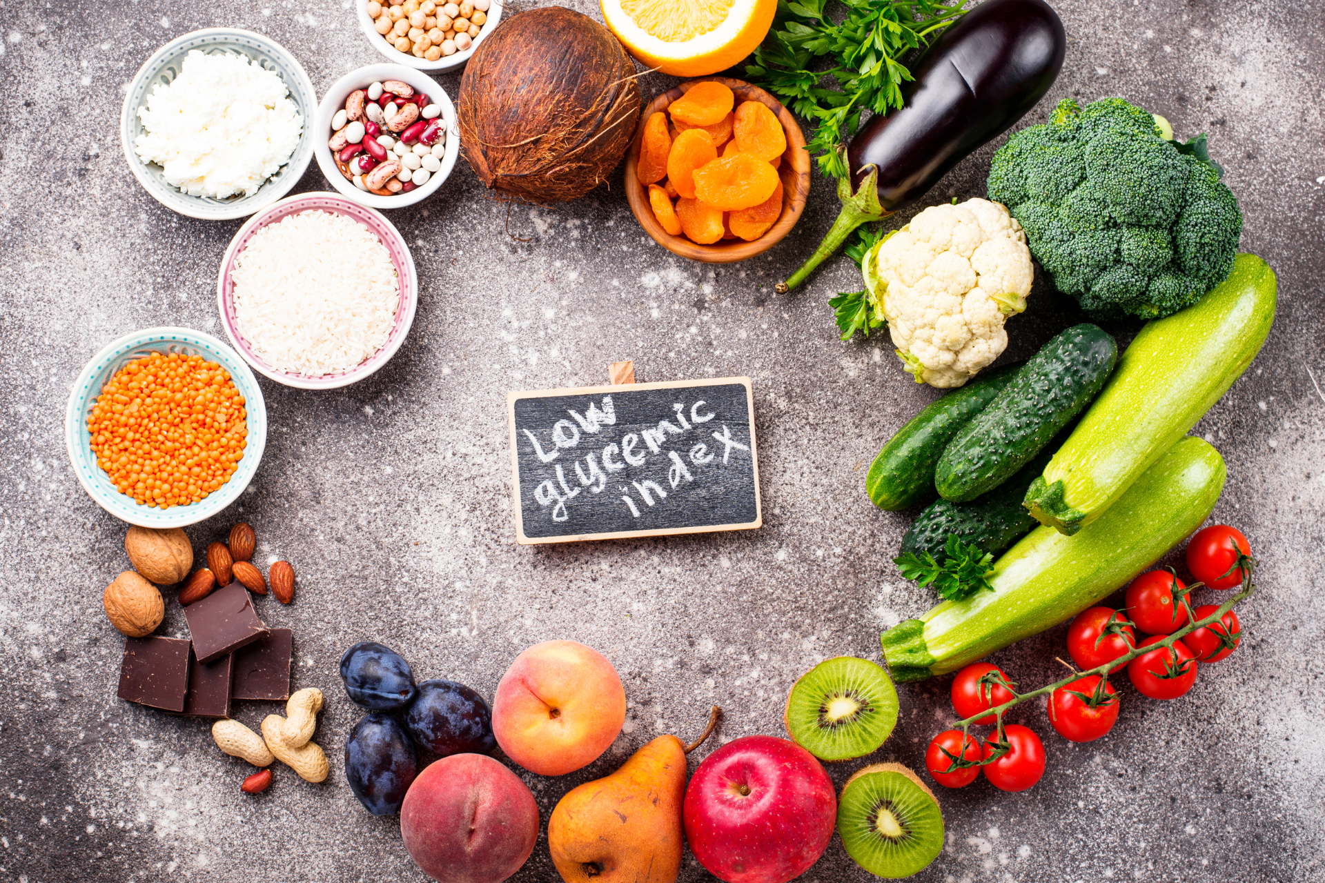 A variety of fruits and vegetables are arranged in a circle on a table.
