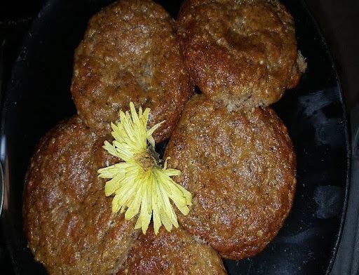 A close up of a plate of food with a yellow flower on top.