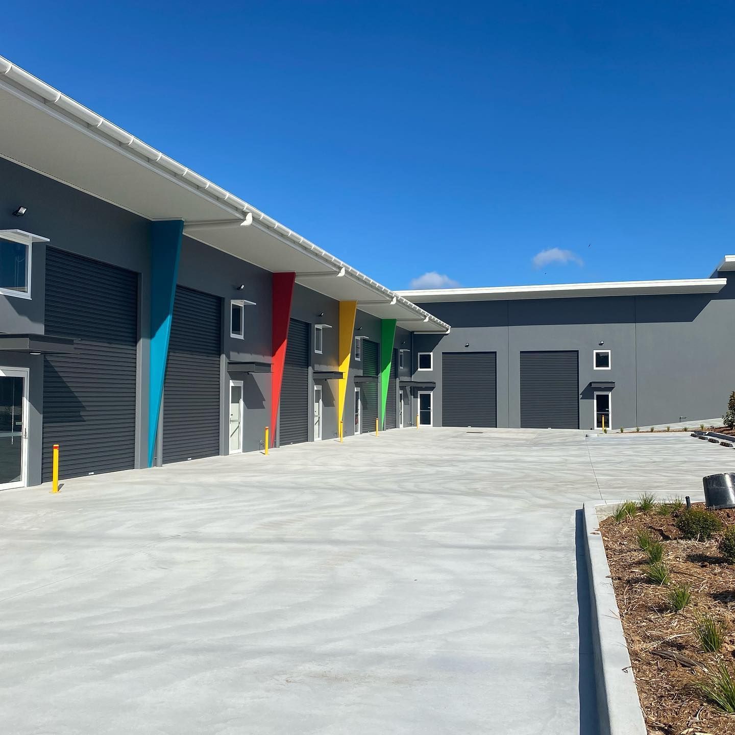 A row of buildings with a concrete driveway in front of them