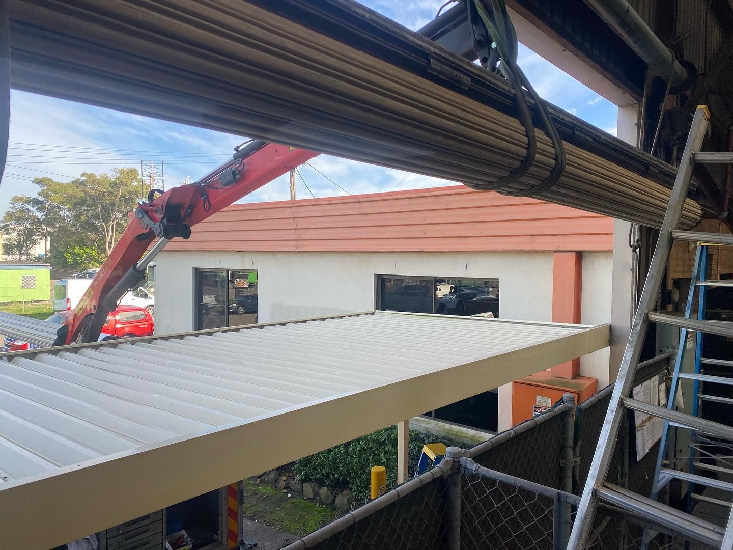 A crane is lifting a roof of a building.