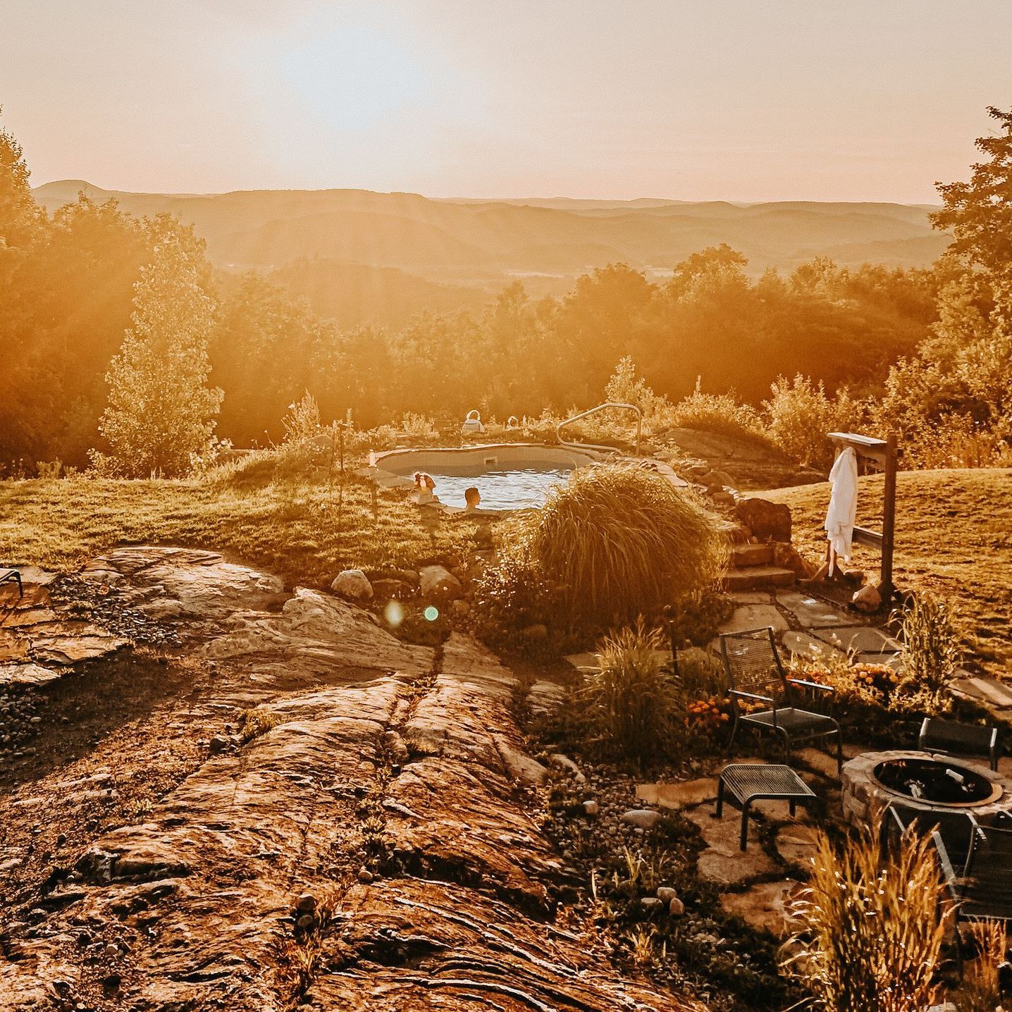 Bathers in a hilltop hot tub at sunset