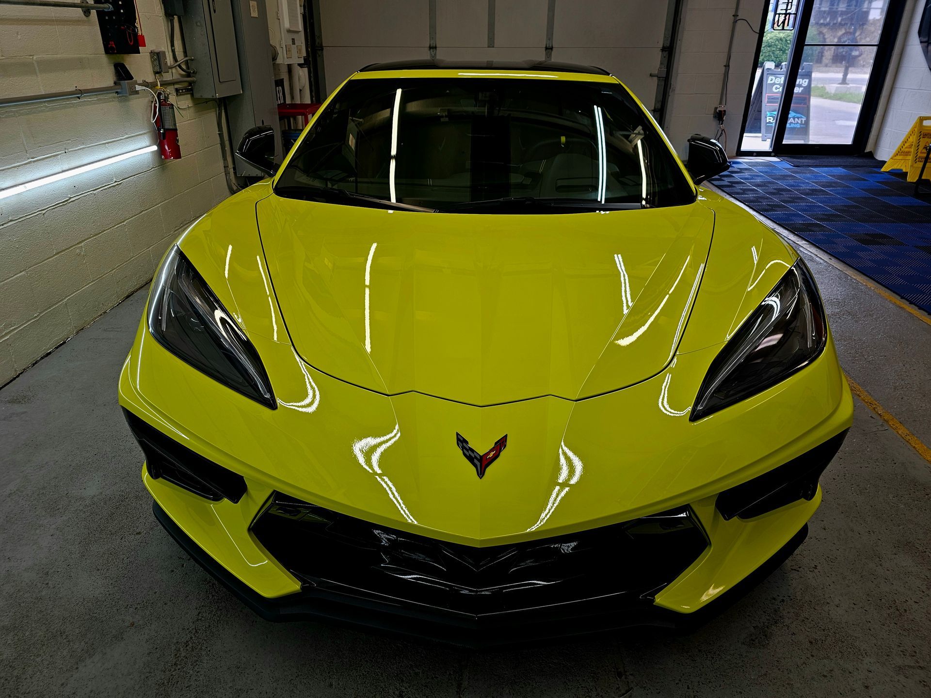 A yellow sports car is parked in a garage.