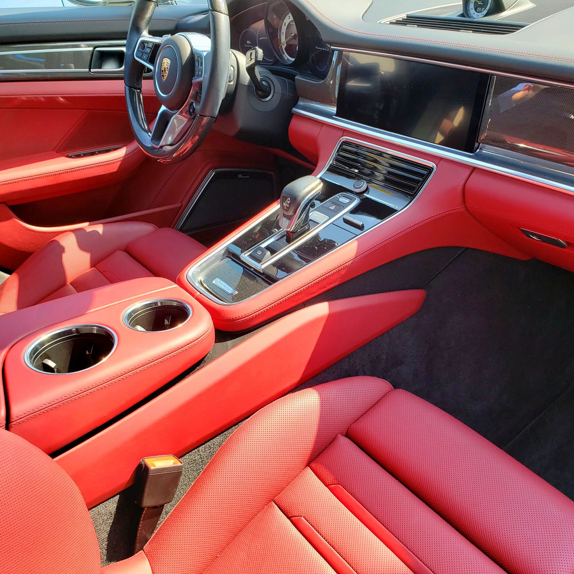 The interior of a car with red seats and a steering wheel