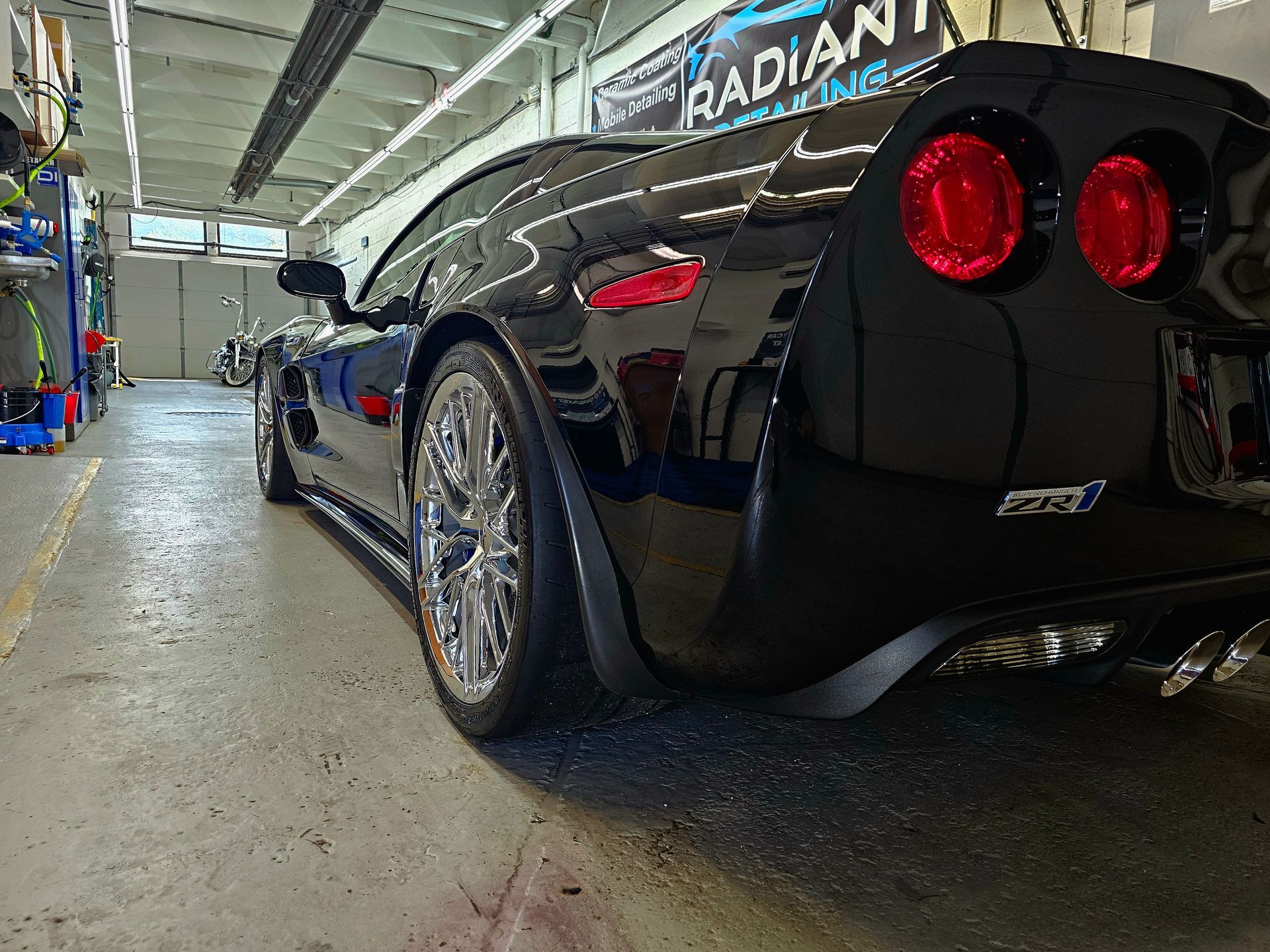 A black sports car is parked in a garage.