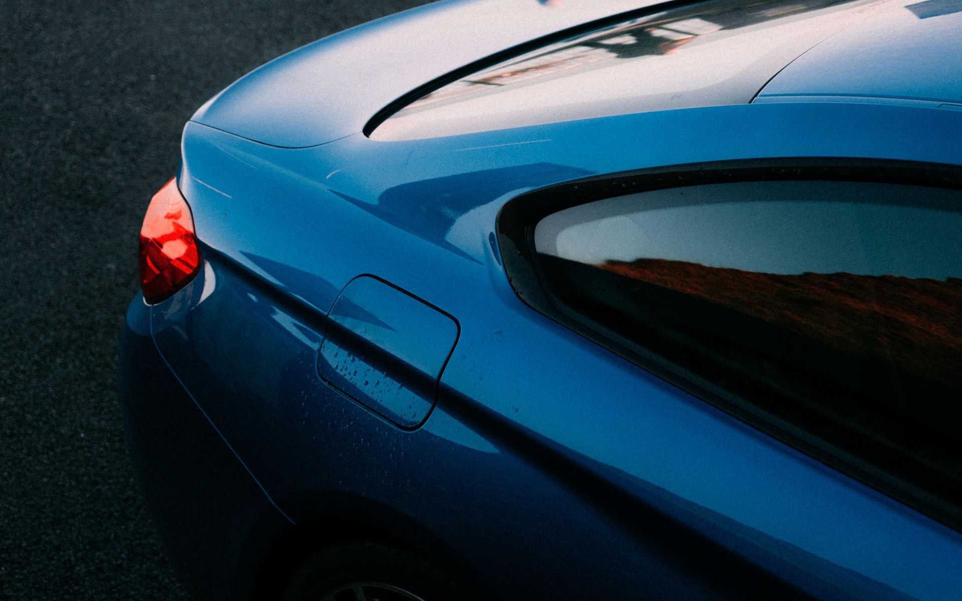 A blue car is parked on the side of the road.