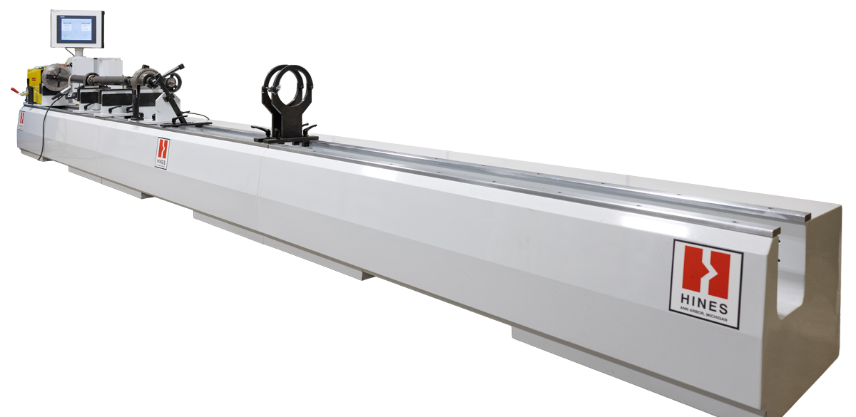 A person placing a tire on a yellow rack filled with many tires in a garage setting.