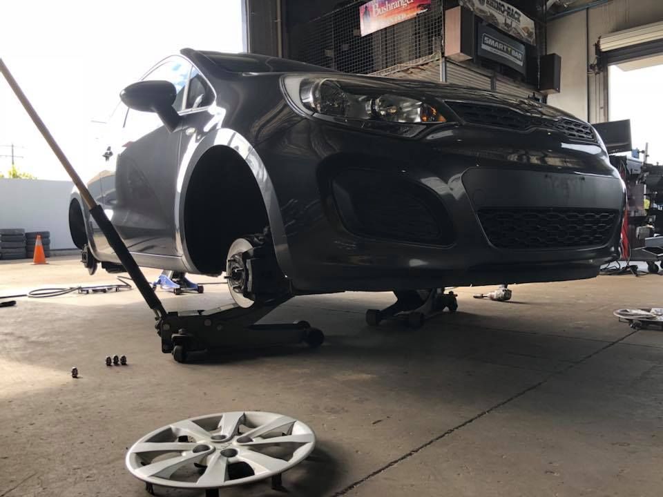 A Car Is Sitting on A Jack in A Garage — Torque Tyres & Trailer Spares Cairns in Cairns, QLD