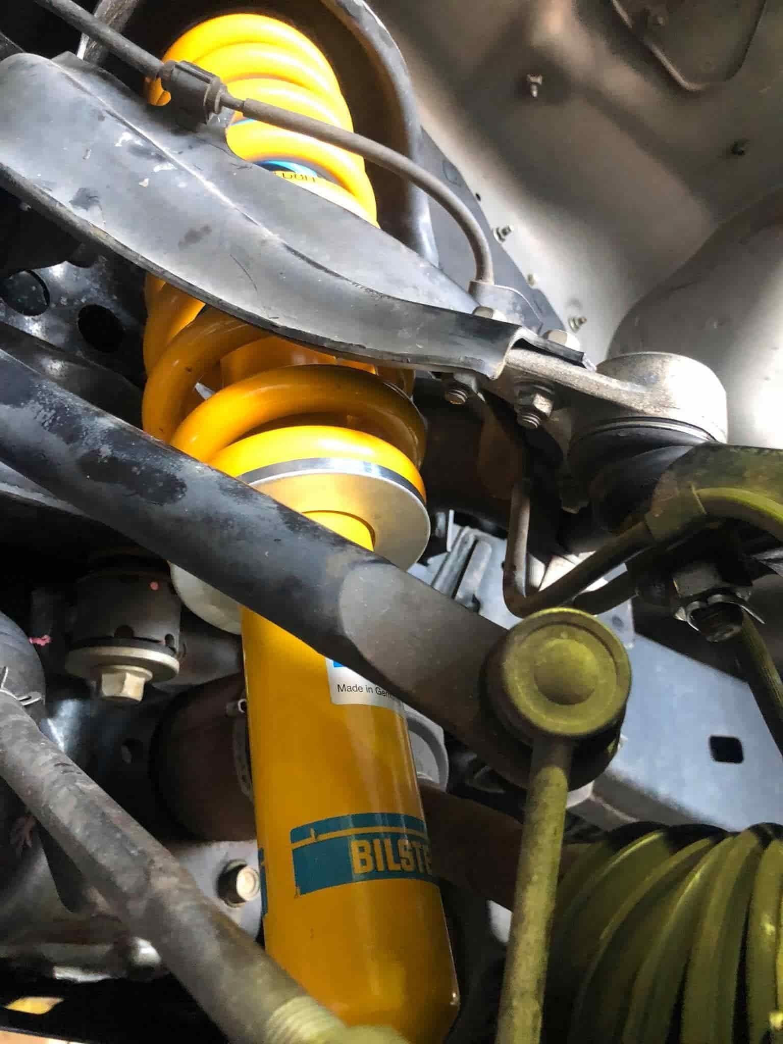 A Close-Up of A Yellow Shock Absorber on A Car — Torque Tyres & Trailer Spares Cairns in Cairns, QLD