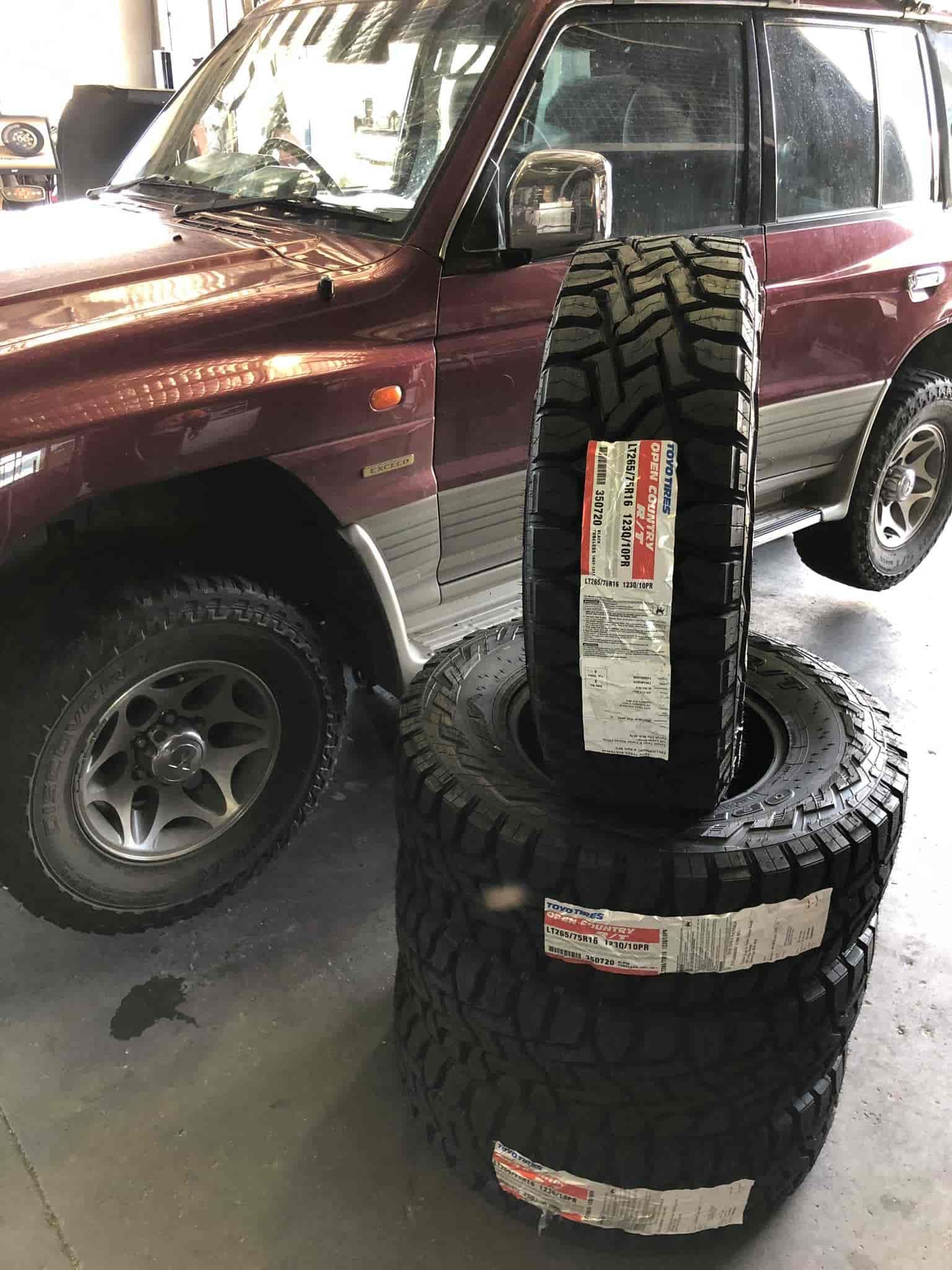 A Red SUV Next to A Pile of Tires — Torque Tyres & Trailer Spares Cairns in Cairns, QLD