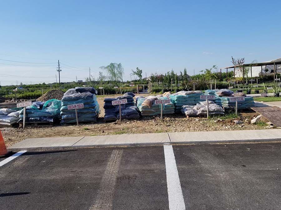 A lot of bags of dirt are sitting on the side of the road