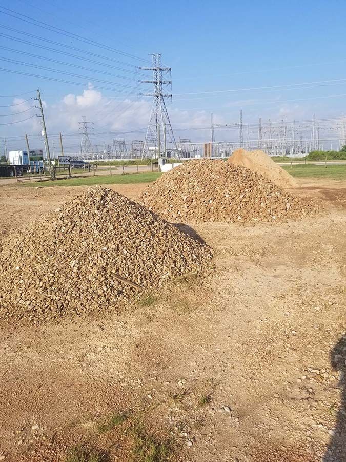 There are two piles of dirt in the middle of a field.