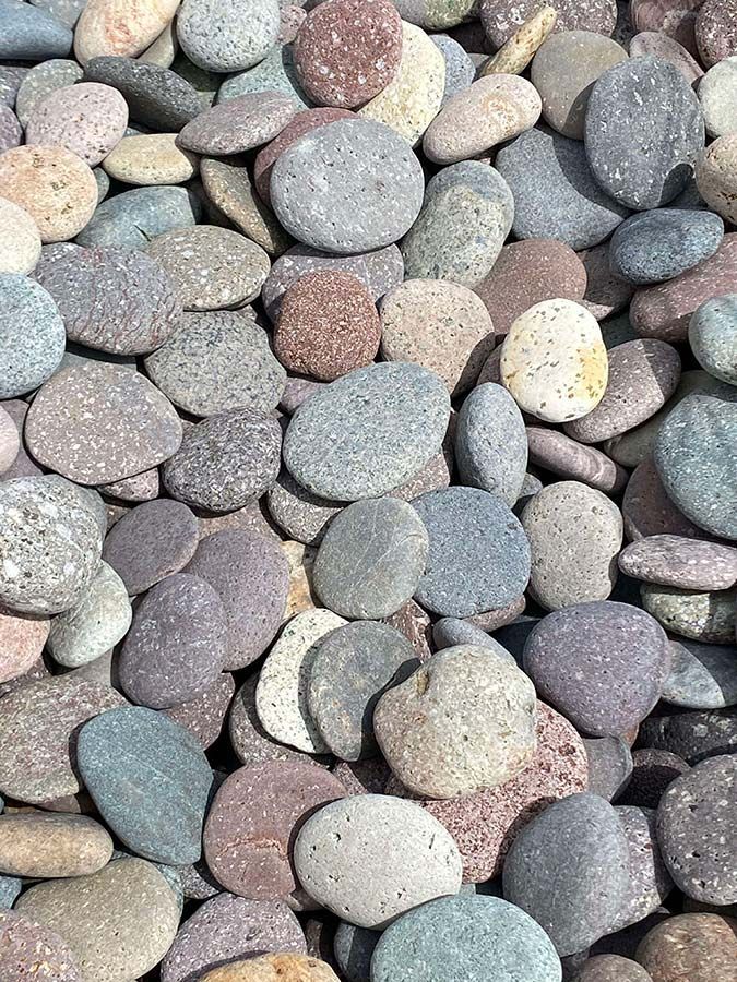 A pile of rocks of different colors and sizes are sitting on top of each other.