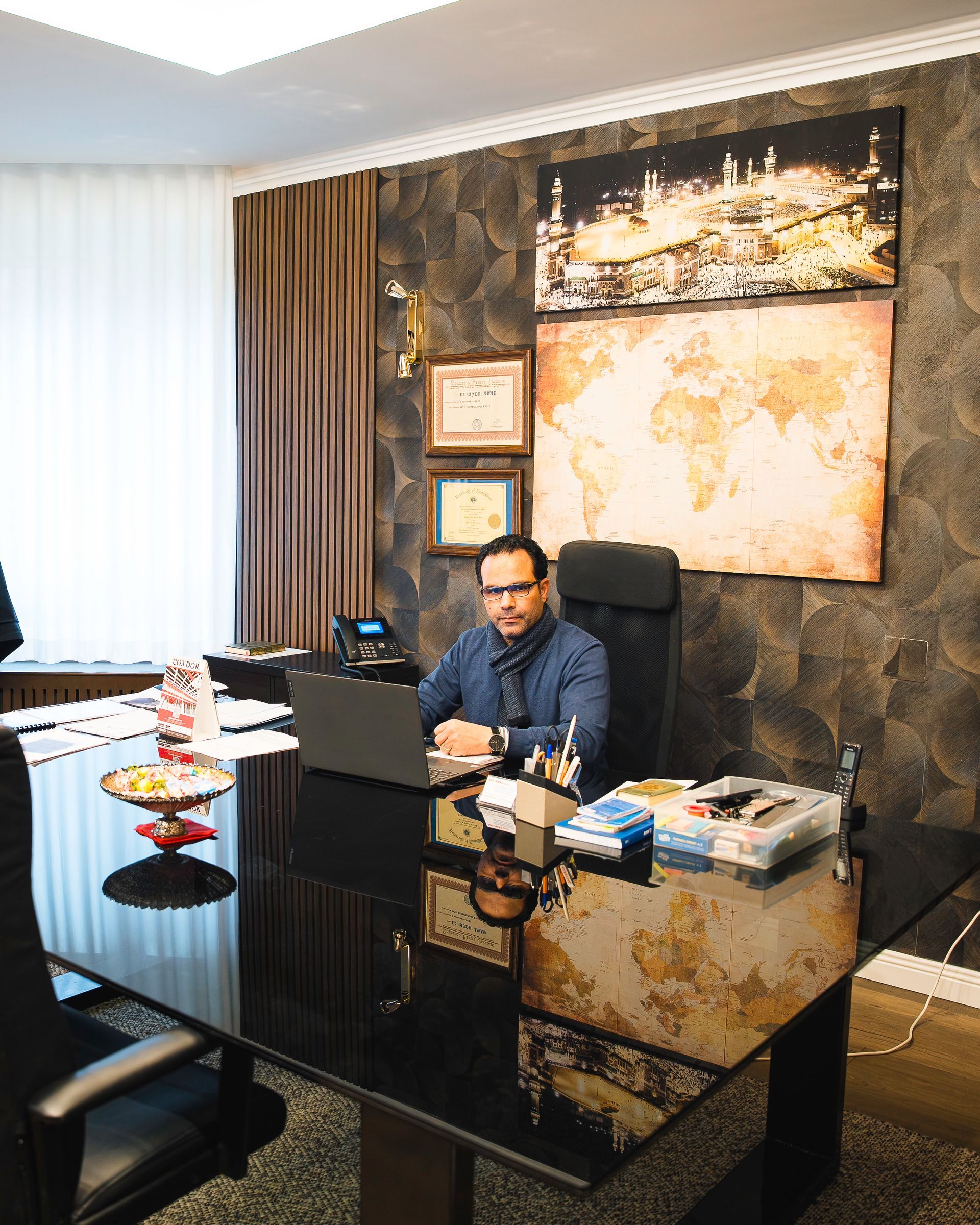 Edifici bianchi a più piani contro un cielo azzurro, con alberi in primo piano.