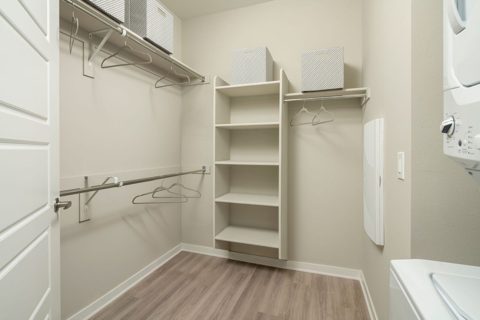 Walk-in closet with shelves, hanging rods, and storage bins