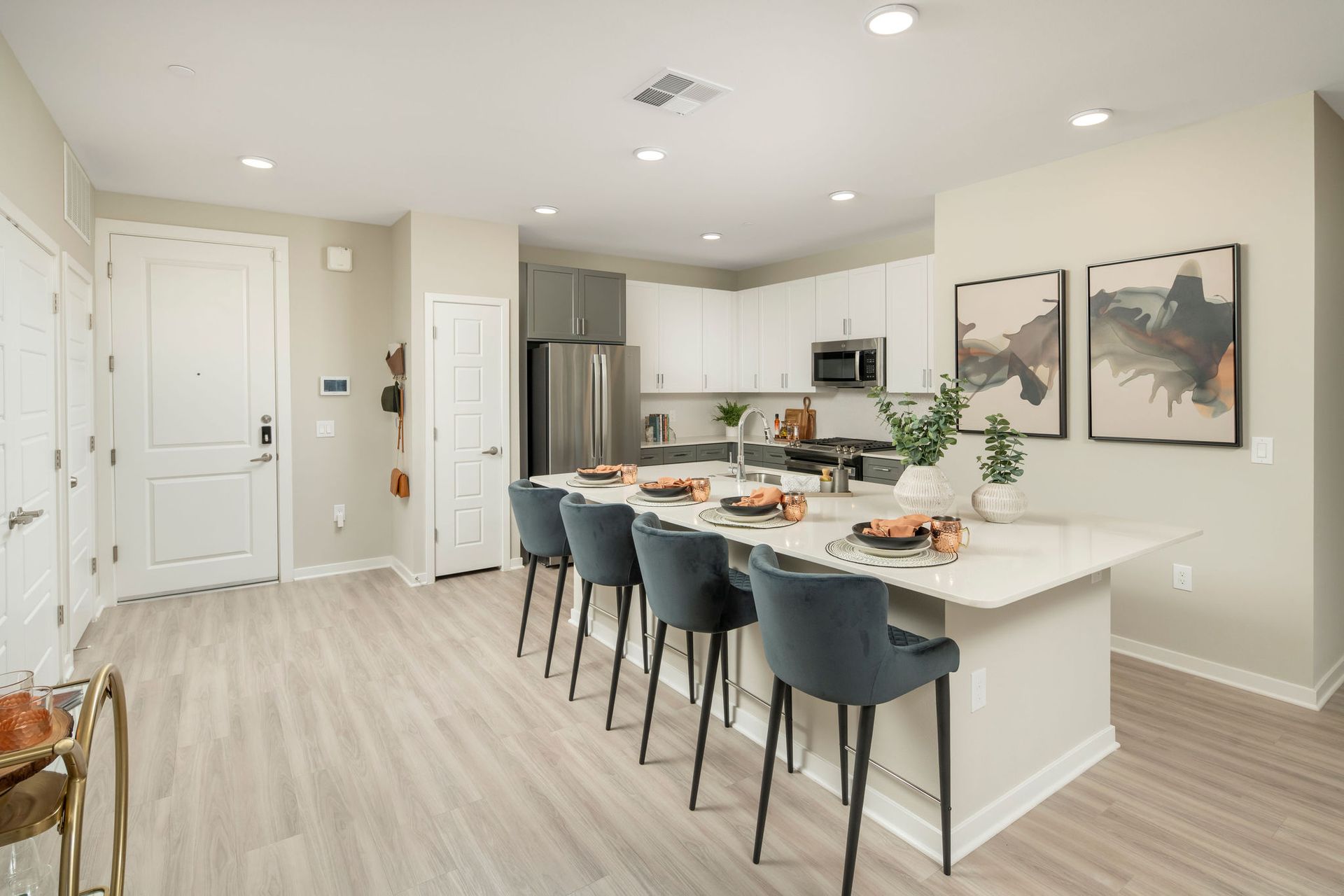 Open-concept kitchen with an island, white cabinetry, and stainless-steel appliances.