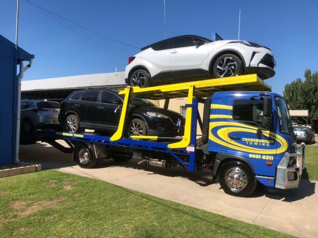 A Tow Truck is Towing a Car on the Highway — Crossborder Towing in Albury, NSW