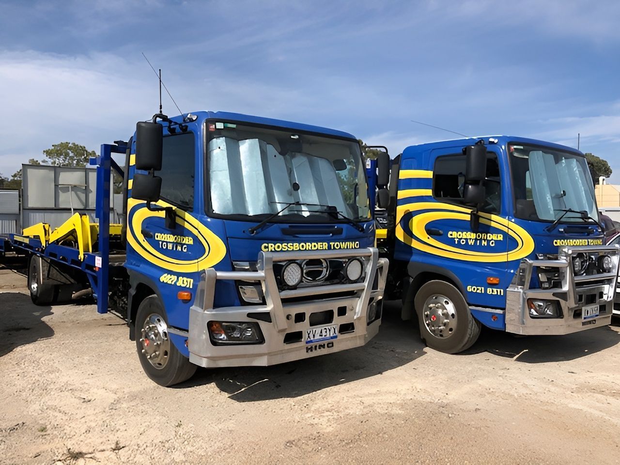 two blue trucks are parked side by side — Crossborder Towing in Howlong, NSW