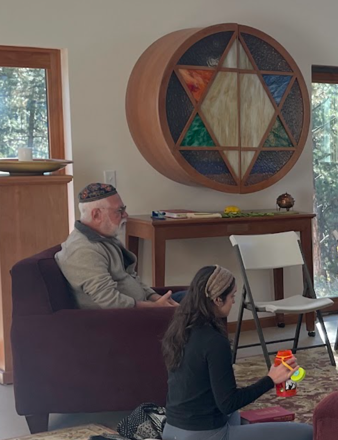 Man sitting in a chair teaching a group of students