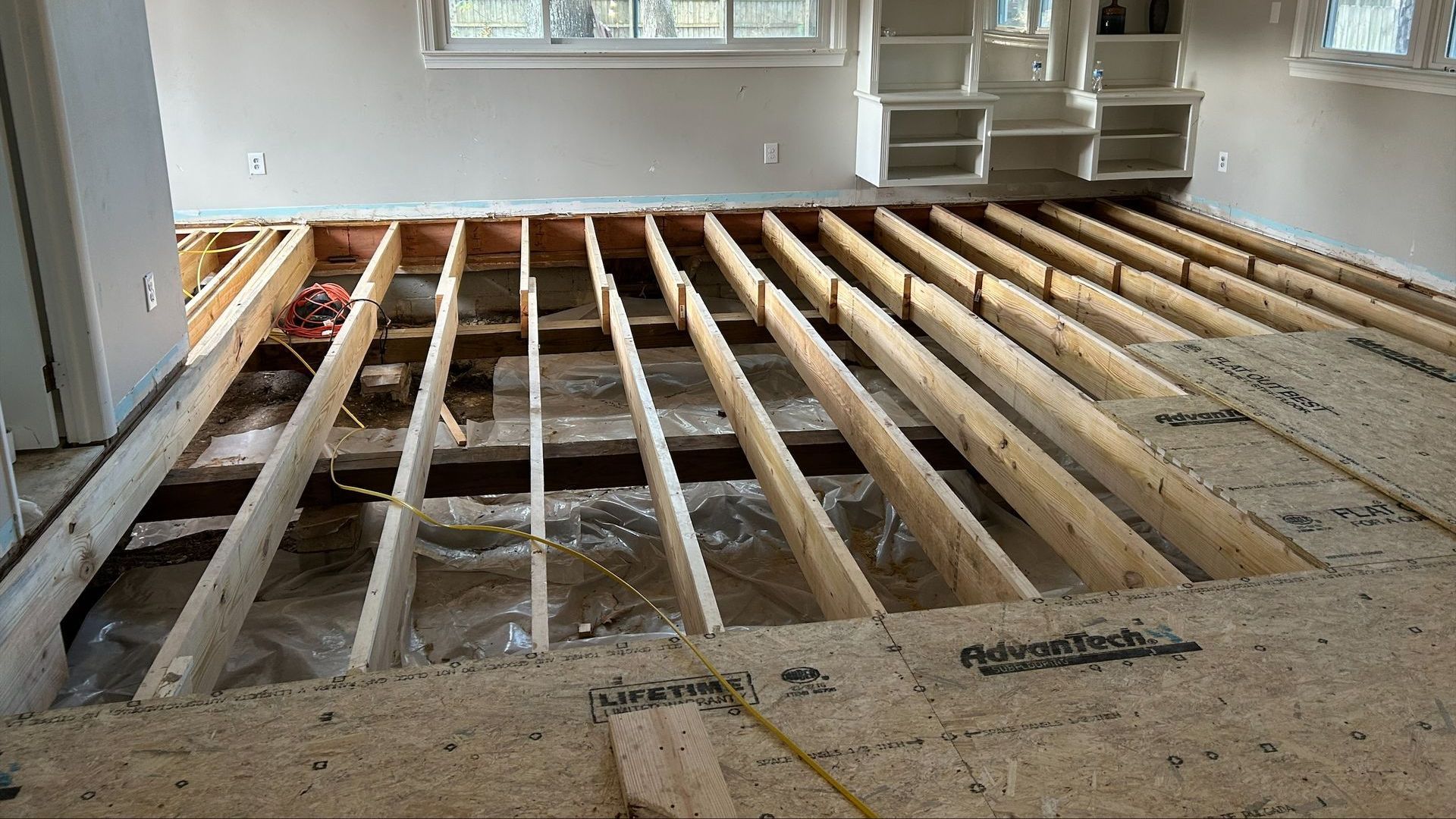 A wooden floor is being built in a living room.