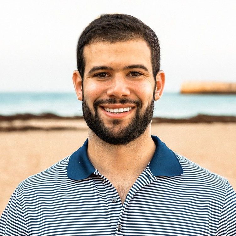 Founder Austin Morin in a striped shirt is smiling on the beach.