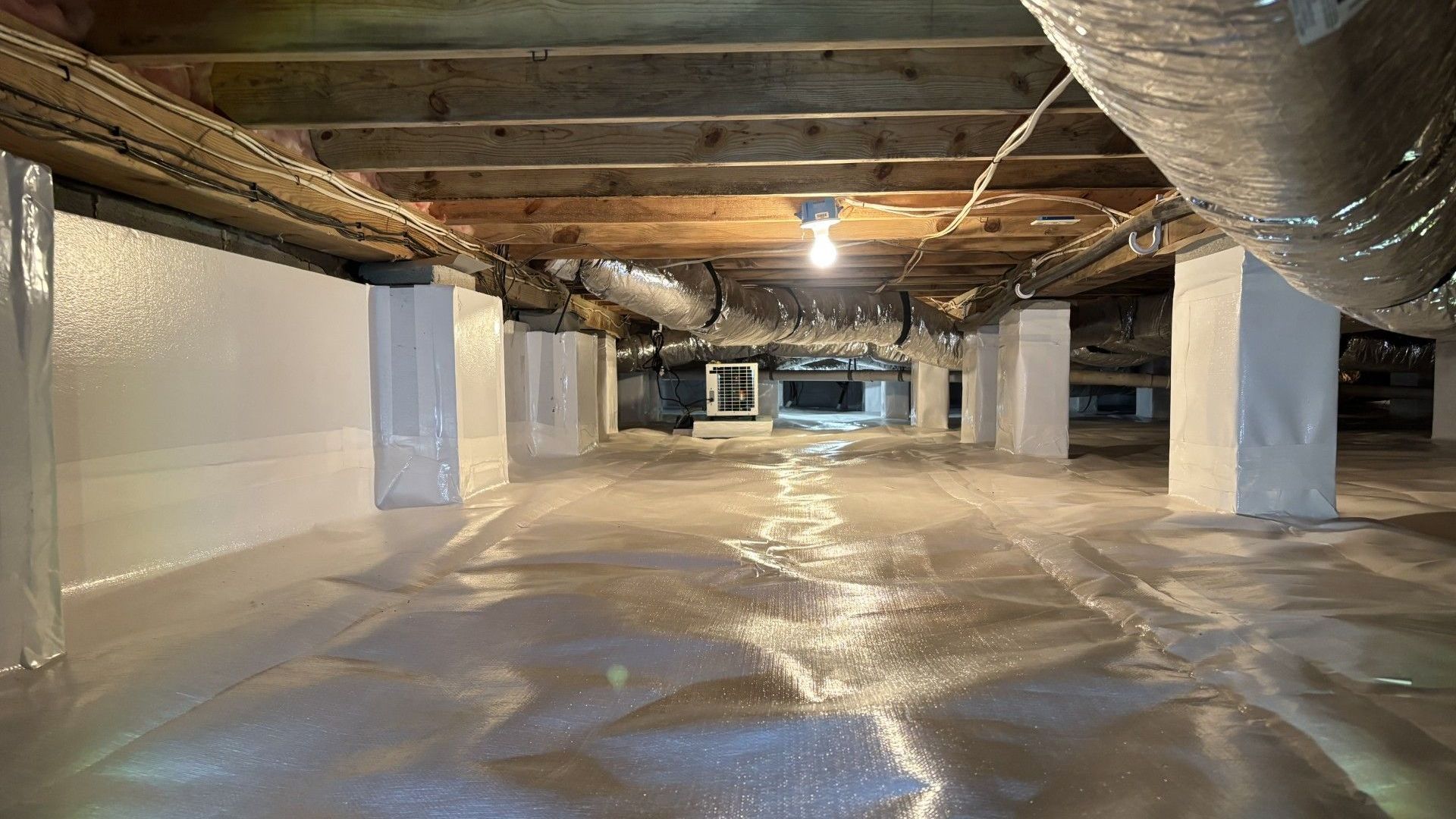 A basement filled with lots of pipes and ducts.