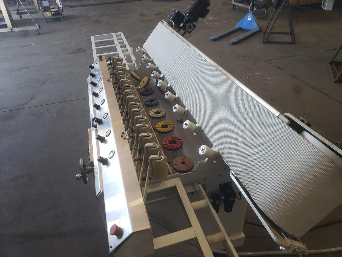 Machinery with multiple spools, various colored discs, and white covering. Industrial setting.