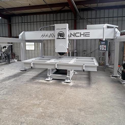 White industrial building with attached equipment, a worker, and a clear sky.