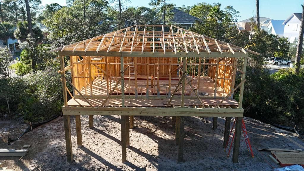 Wooden structure on stilts under construction with framing visible.