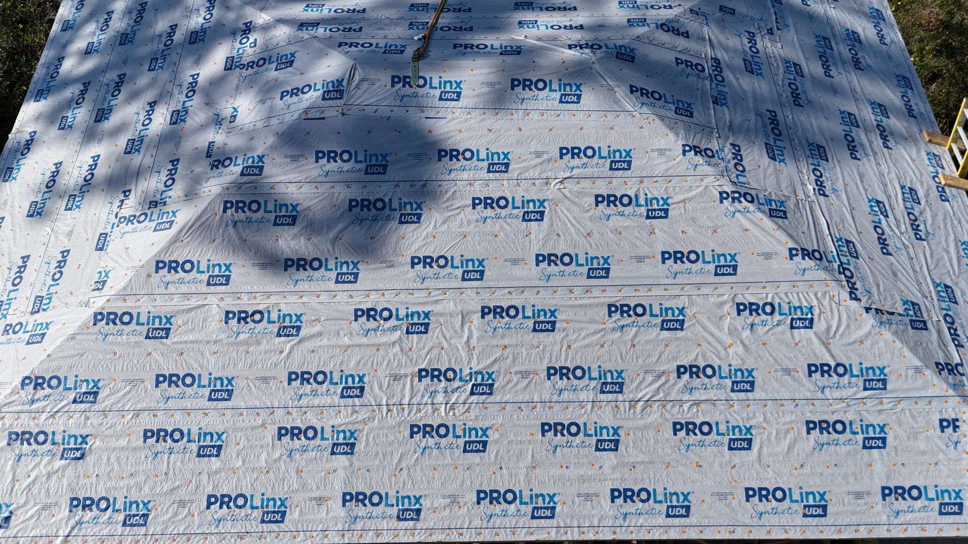 Man standing in a modern kitchen with blue island and white cabinets.
