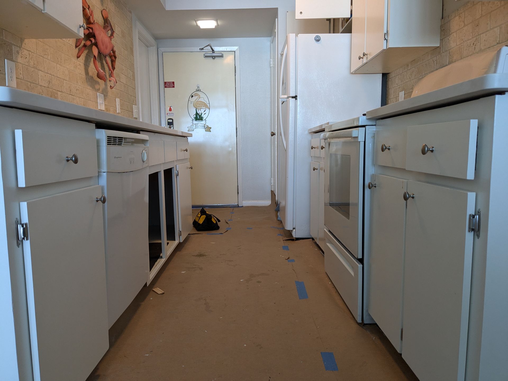 Spacious white bathroom with gray countertop, large mirror, and freestanding tub.
