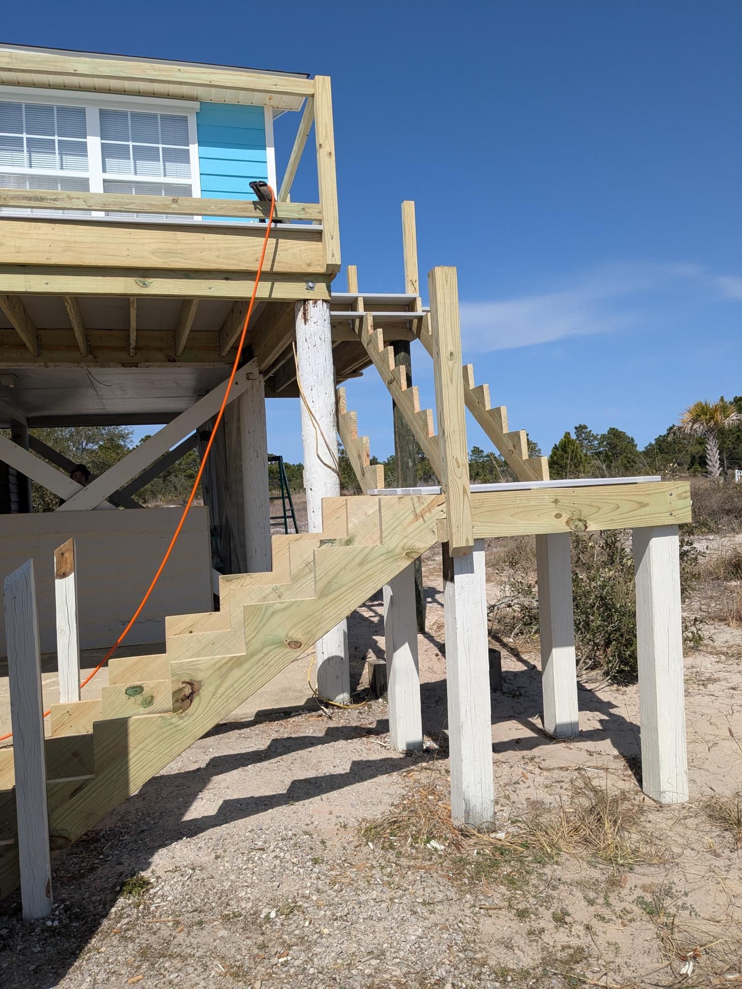 New wooden stairs being built to access an elevated beach house.