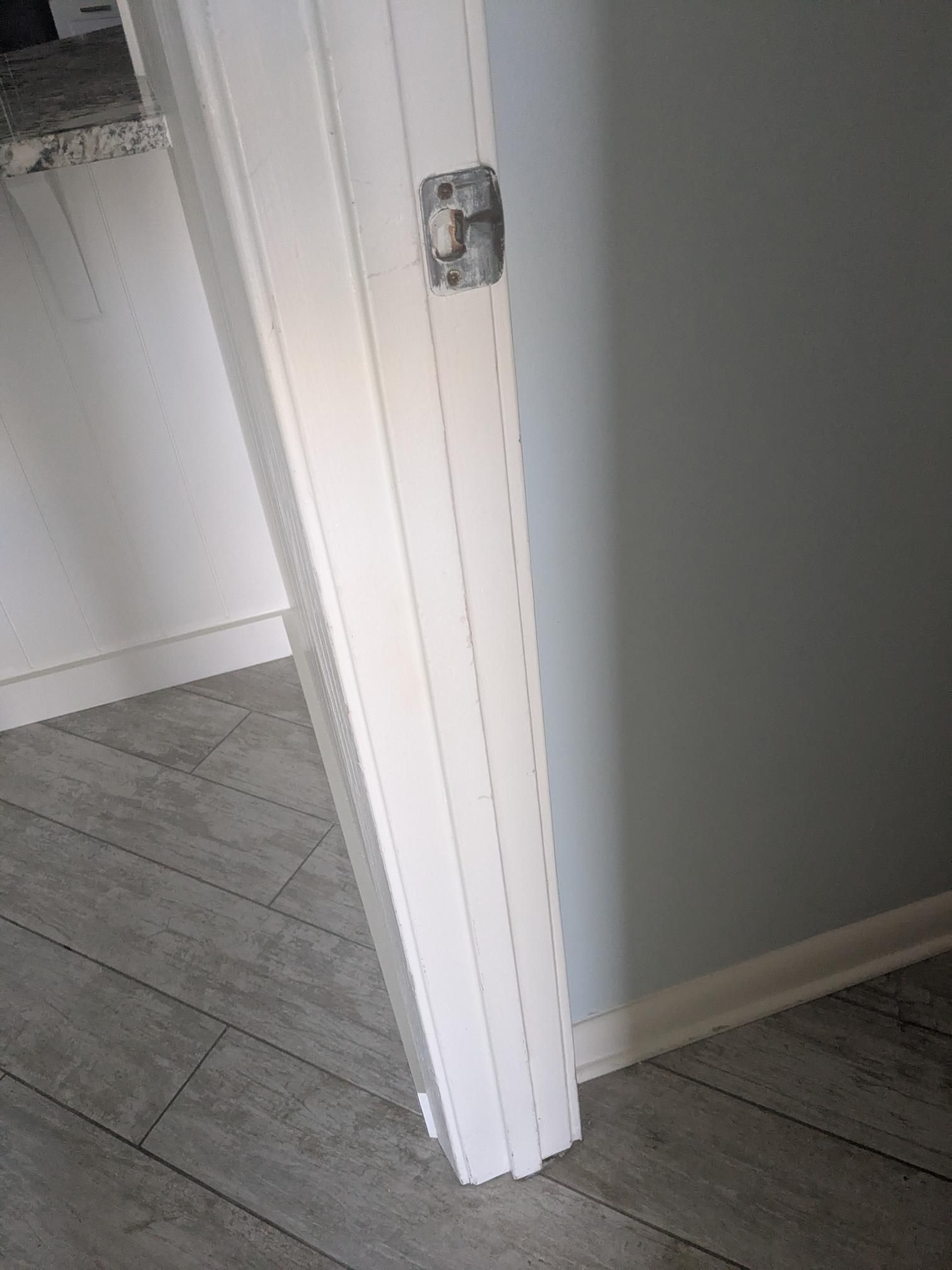 White door frame in an opening, gray walls and flooring.