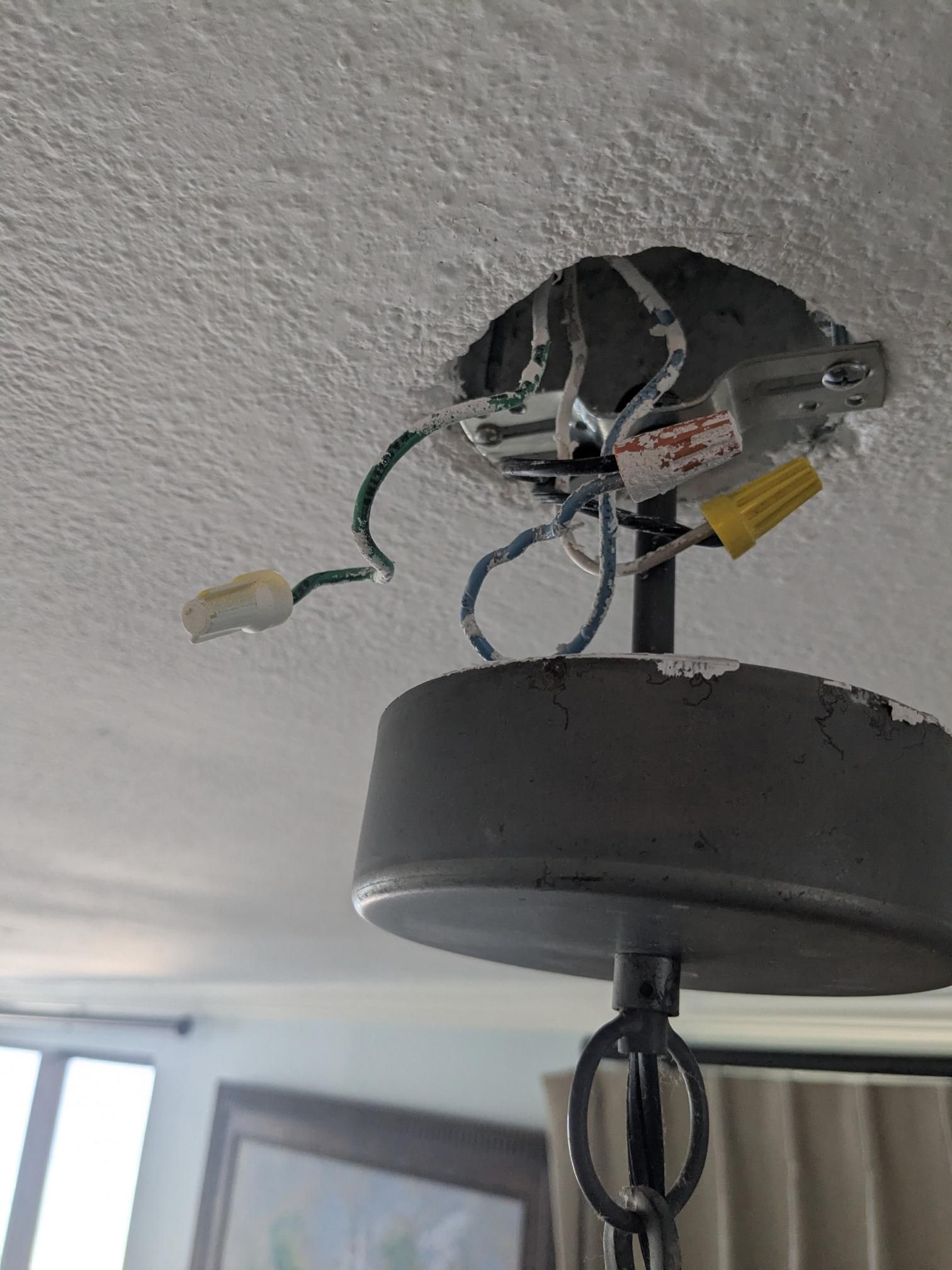 Ceiling light fixture with exposed wiring, wires connected with wire connectors.
