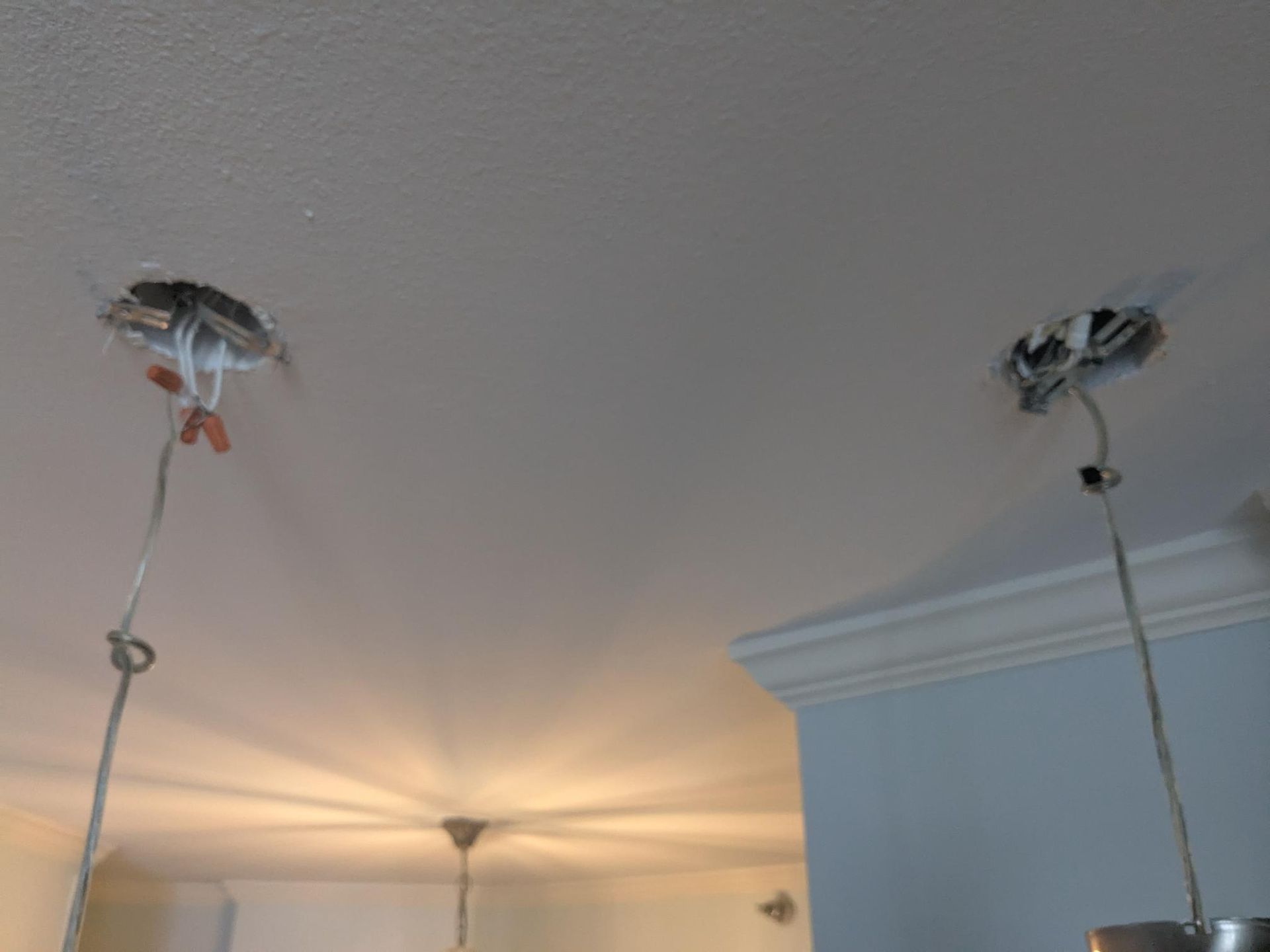 Two ceiling electrical boxes with exposed wires, ready for light fixtures.