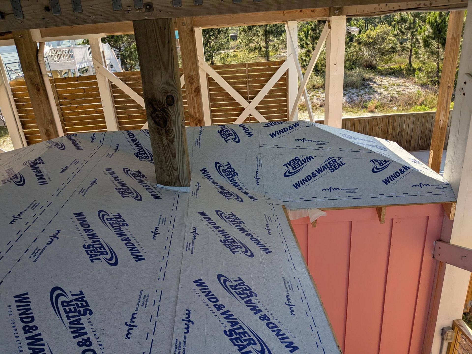 Roofing work in progress; sheathing covered with Wind & Water Seal material, view from inside the structure.