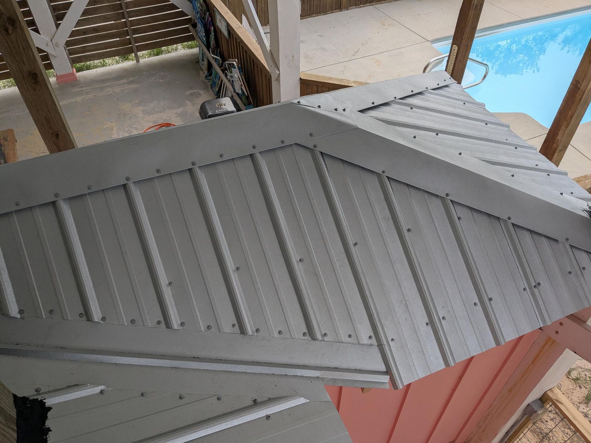 Gray metal roofing installed on a building under construction, viewed from below.