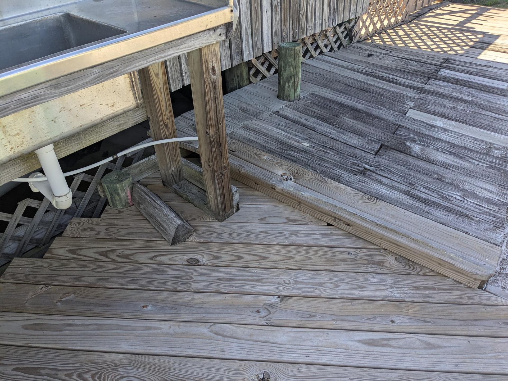 Wooden dock with a stainless steel sink, weathered wood.