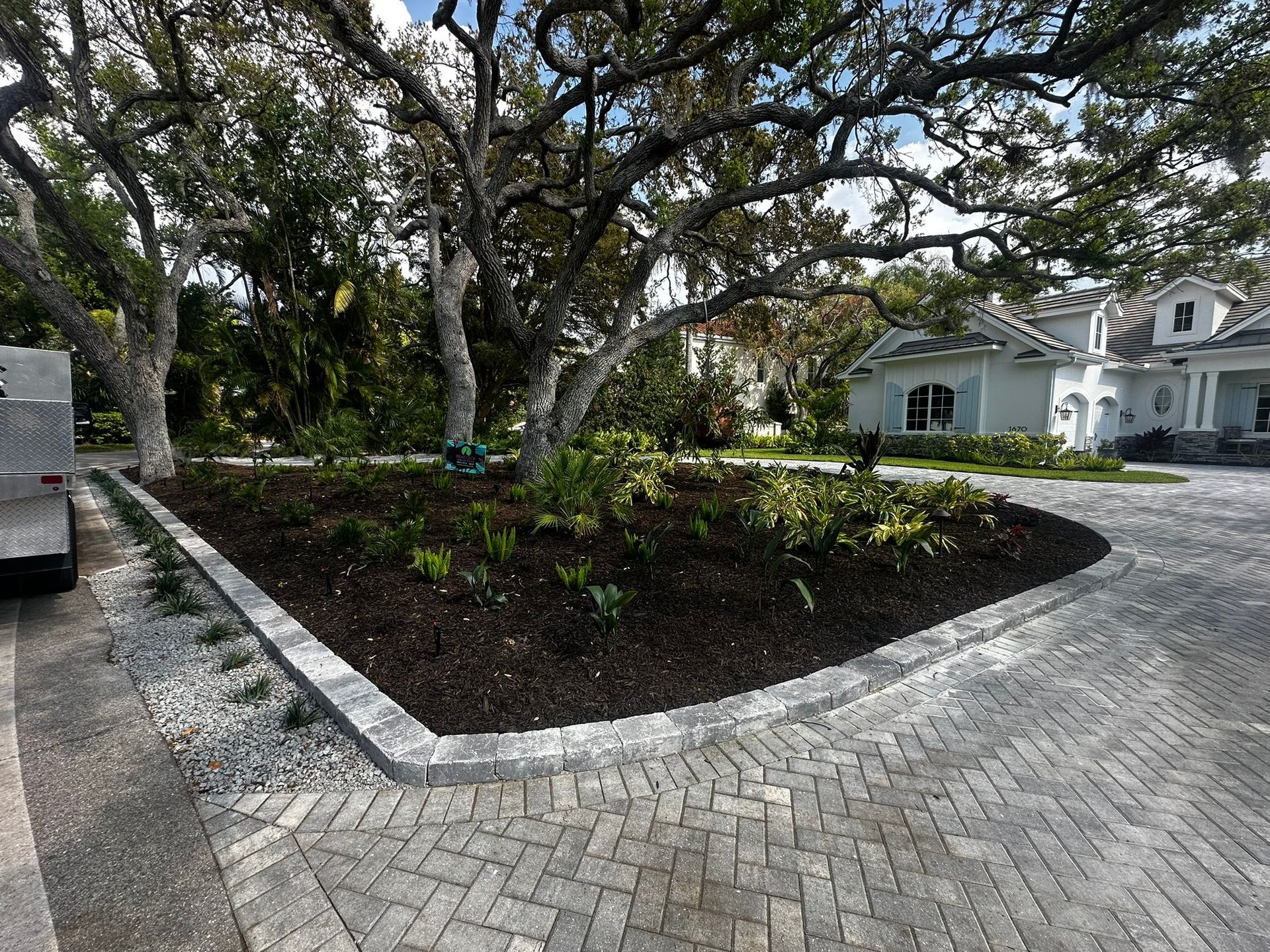Custom landscape installation with hardscape, new plantings, irrigation, and integrated lighting in The Landings