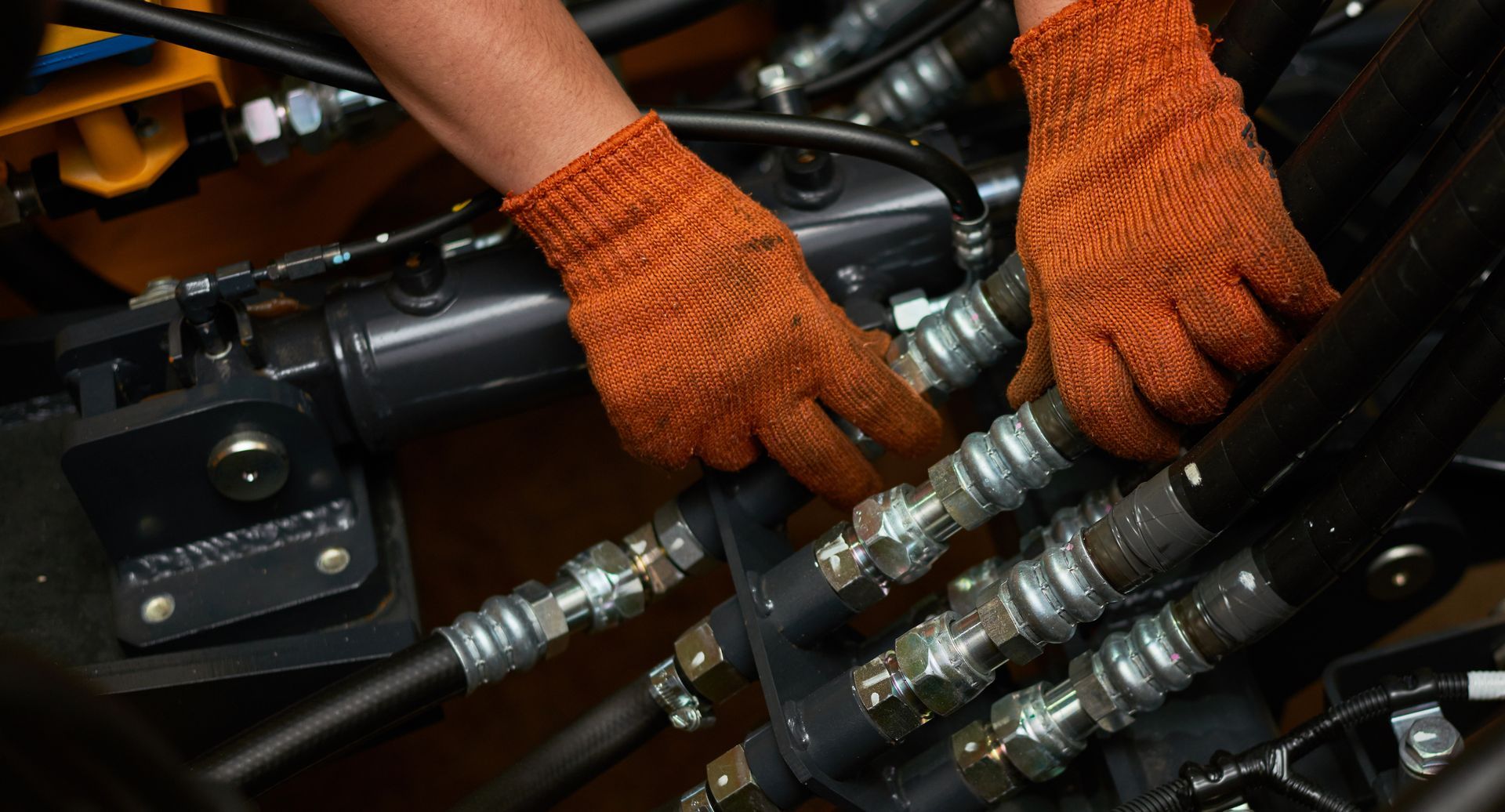 Low key photo of hydraulic pipes maintenance on heavy industry machine. Low key photo of hydraulic pipes maintenance on heavy industry machine.