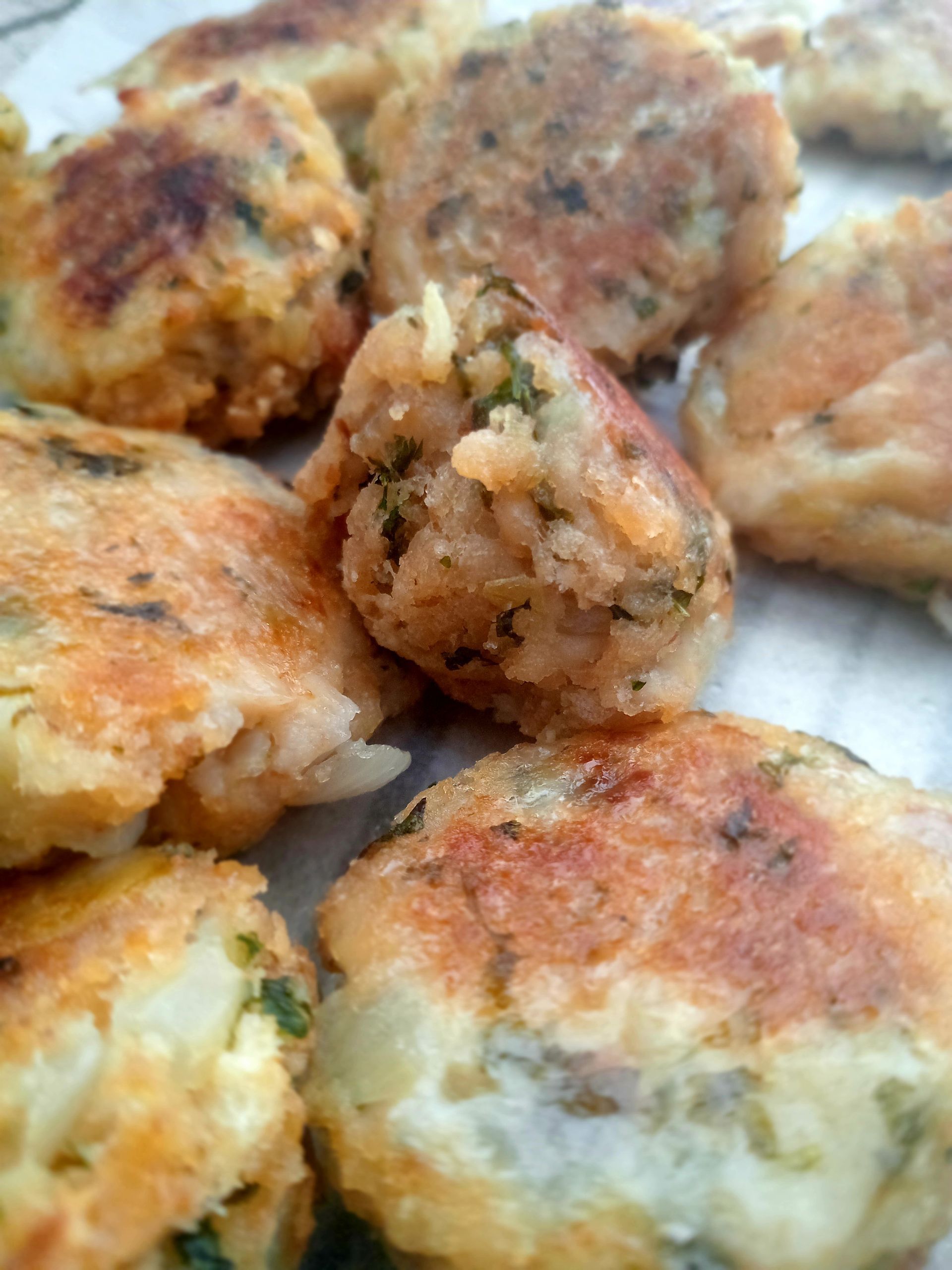 Golden brown, pan-fried patties. Close up shows visible rice and herbs.