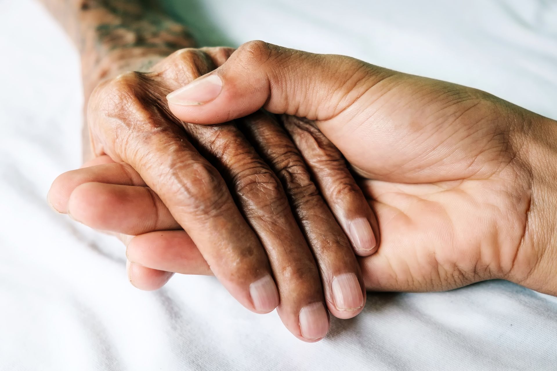 Eine Krankenschwester spricht mit einem Patienten in einem Krankenhausbett.