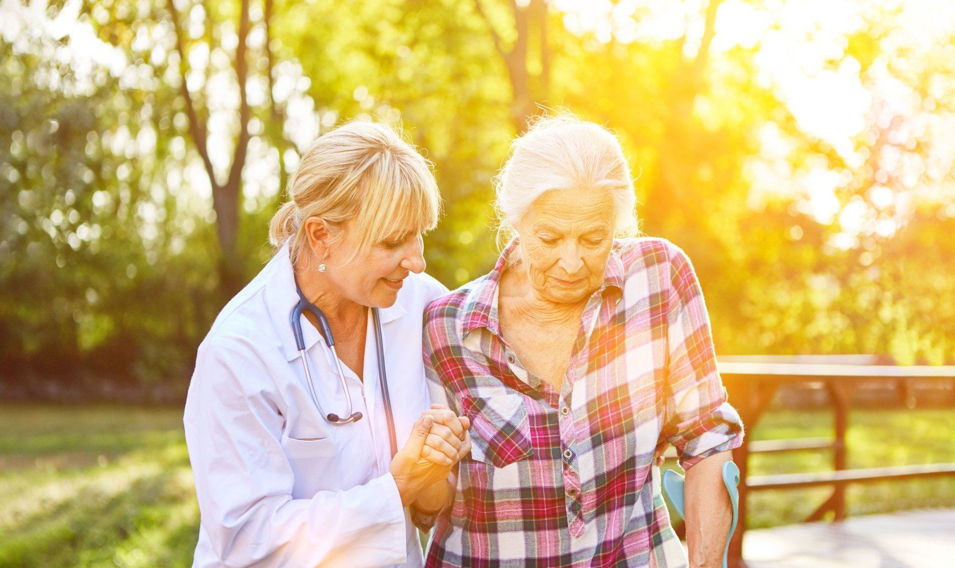 Bewohner eines Pflegeheims spielen in einem sonnigen Raum mit Pflegekräften.